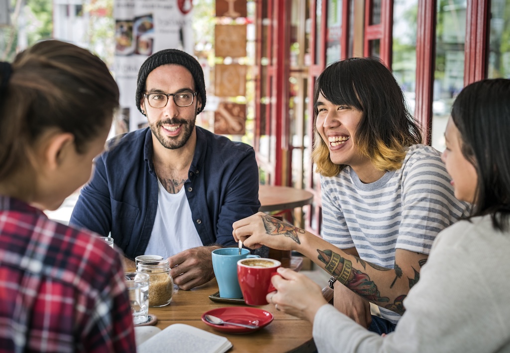 Group of friends in recovery having coffee together and building community after treatment.